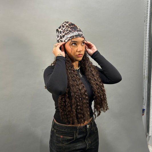 Femme aux longues tresses portant le skull cap léopard PRESTIGE